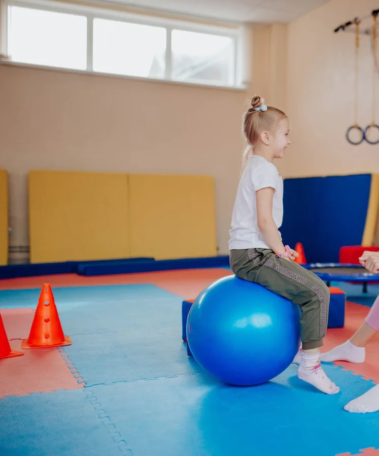 Therapist and a young girl on therapy balls
