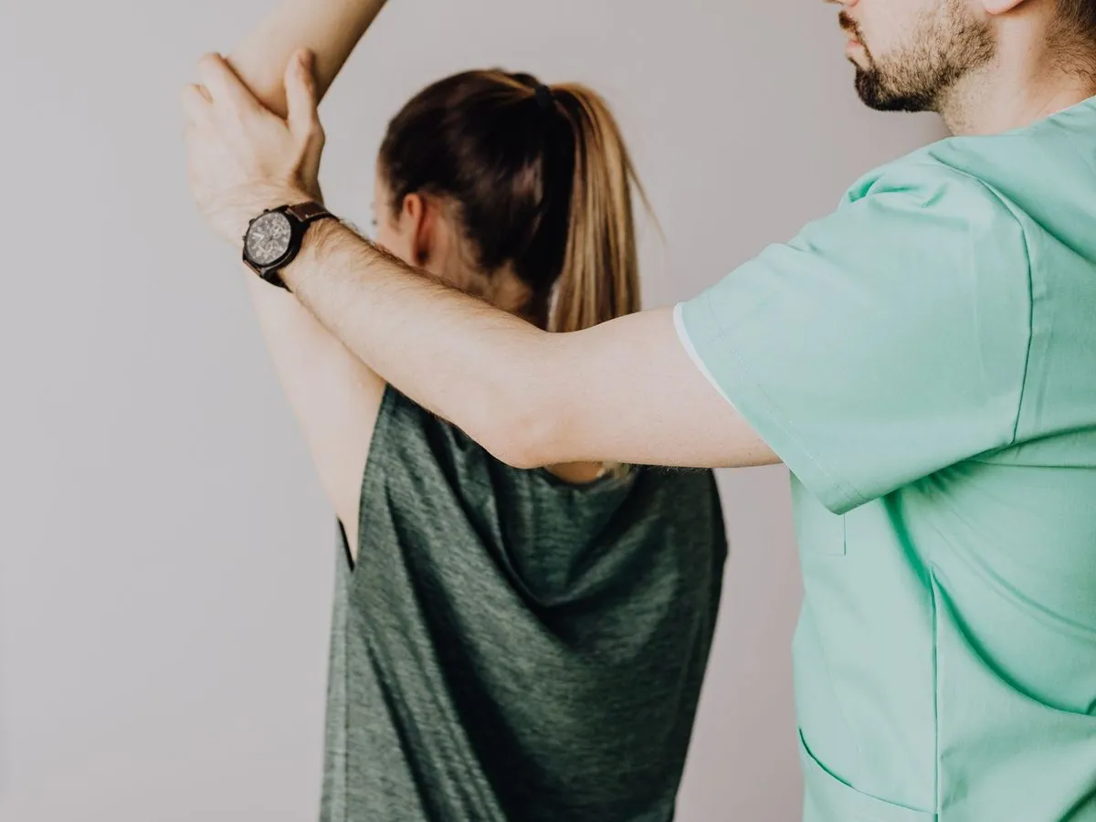 Physiotherapist guiding a shoulder and upper-back stretch