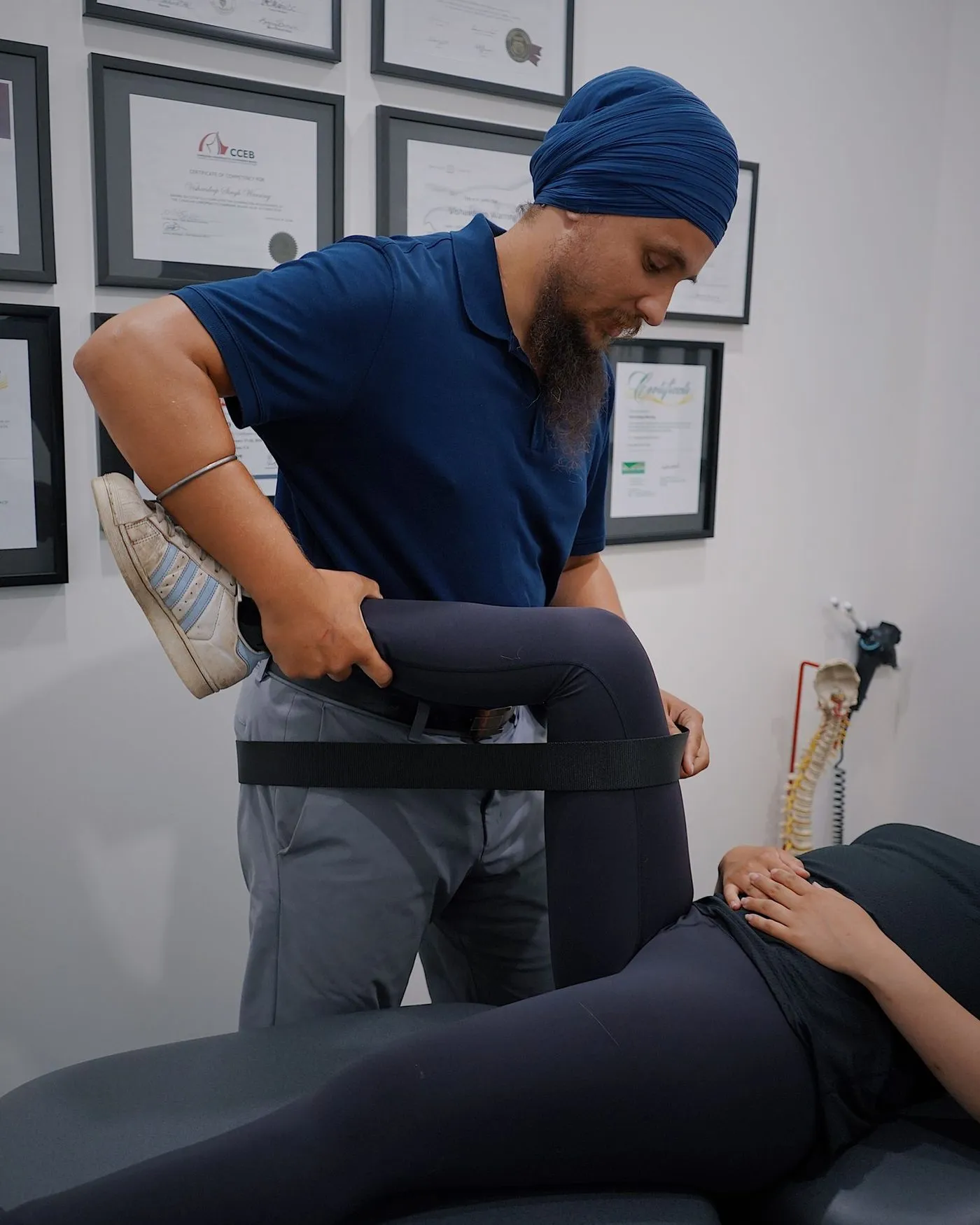 Physiotherapist stretching a patient's hip with a strap